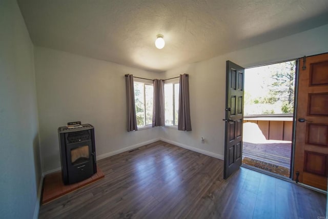 8637 Ponderosa Ln, Pine Valley, CA 91962 - entryway featuring healthy amount of natural light, a wood stove, dark wood finished floors, baseboards, and a textured ceiling
