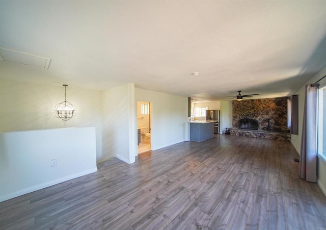8637 Ponderosa Ln, Pine Valley, CA 91962 - unfurnished living room with dark wood-type flooring, a stone fireplace, a ceiling fan, and plenty of natural light