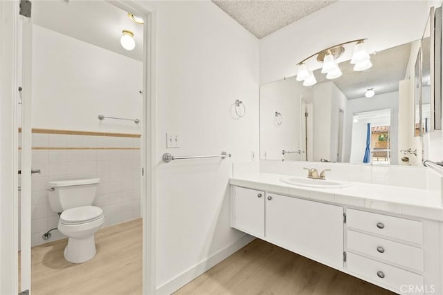 1127 E Del Mar Blvd Unit 235, Pasadena, CA 91106 - bathroom with wood finished floors, a textured ceiling, vanity, toilet, and tile walls