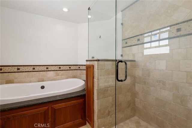 24092 Lapwing Ln, Laguna Niguel, CA 92677 - bathroom with a garden tub, a shower stall, tile walls, and a wainscoted wall