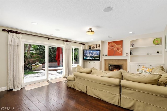 24092 Lapwing Ln, Laguna Niguel, CA 92677 - living room featuring a glass covered fireplace, dark wood finished floors, built in features, baseboards, and a textured ceiling