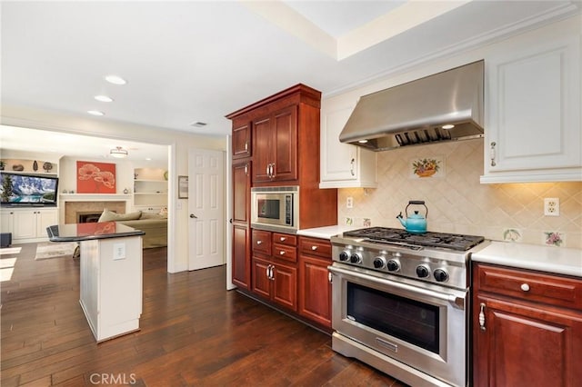 24092 Lapwing Ln, Laguna Niguel, CA 92677 - kitchen with wall chimney exhaust hood, appliances with stainless steel finishes, decorative backsplash, a fireplace, and light countertops