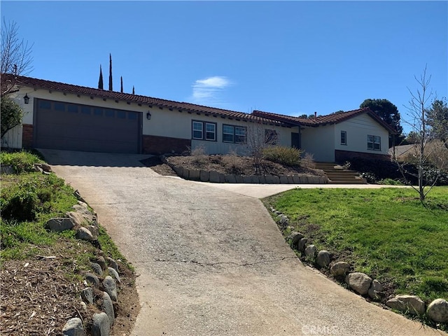 1515 Elizabeth St, Redlands, CA 92373 - view of front of house with an attached garage, concrete driveway, brick siding, and a front yard