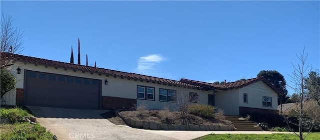 1515 Elizabeth St, Redlands, CA 92373 - mediterranean / spanish-style home with an attached garage, concrete driveway, brick siding, and a tile roof