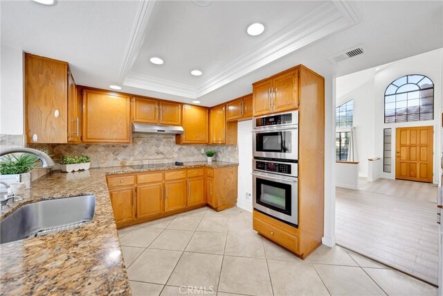867 Winding Brook Ln, Walnut, CA 91789 - kitchen featuring a tray ceiling, a sink, under cabinet range hood, stainless steel double oven, and crown molding