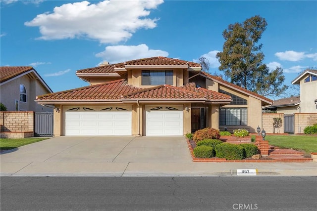867 Winding Brook Ln, Walnut, CA 91789 - mediterranean / spanish-style house featuring stucco siding, an attached garage, a tile roof, driveway, and a gate