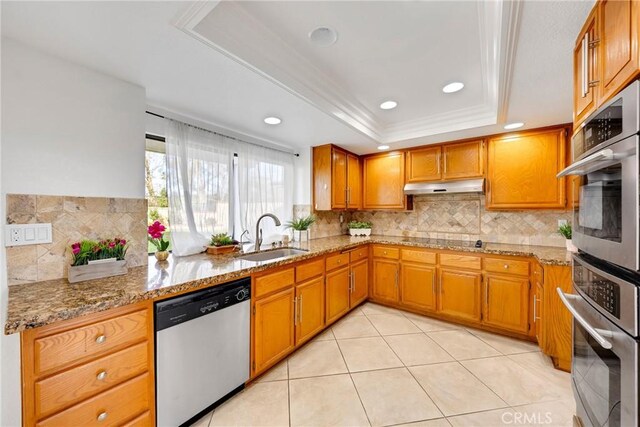 867 Winding Brook Ln, Walnut, CA 91789 - kitchen with stainless steel appliances, a sink, a tray ceiling, under cabinet range hood, and tasteful backsplash