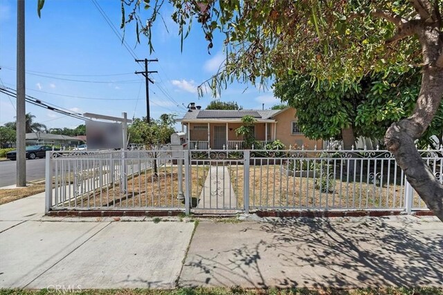 1218 S Sultana Ave Unit A, Ontario, CA 91761 - ranch-style home with a fenced front yard, roof mounted solar panels, stucco siding, and a chimney
