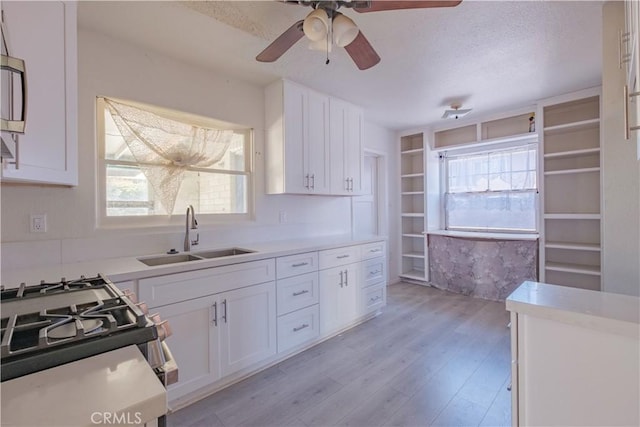 17196 Barbee St, Fontana, CA 92336 - kitchen with a sink, white cabinets, light wood finished floors, and a textured ceiling
