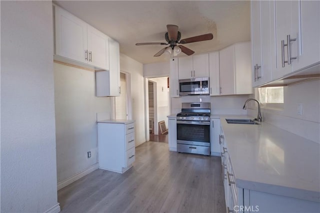 17196 Barbee St, Fontana, CA 92336 - kitchen featuring stainless steel appliances, a sink, ceiling fan, and light wood-style floors