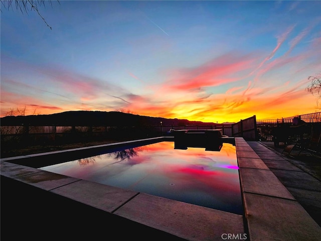 6683 Sherman Hoyt Ave Unit 29, Palms, CA 92277 - pool at dusk featuring a fenced backyard