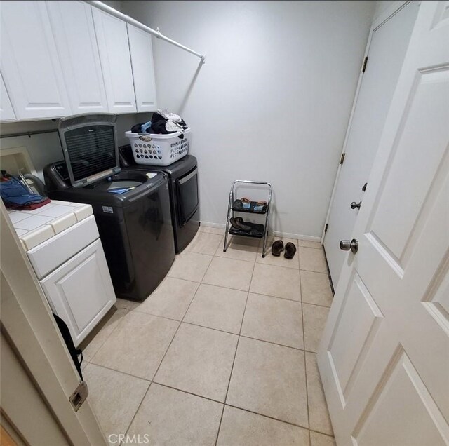 6683 Sherman Hoyt Ave Unit 29, Palms, CA 92277 - washroom featuring cabinet space, light tile patterned floors, independent washer and dryer, and baseboards