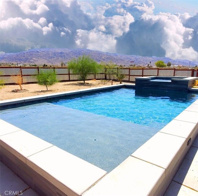 6683 Sherman Hoyt Ave Unit 29, Palms, CA 92277 - view of swimming pool with an in-ground hot tub, a fenced backyard, and a mountain view