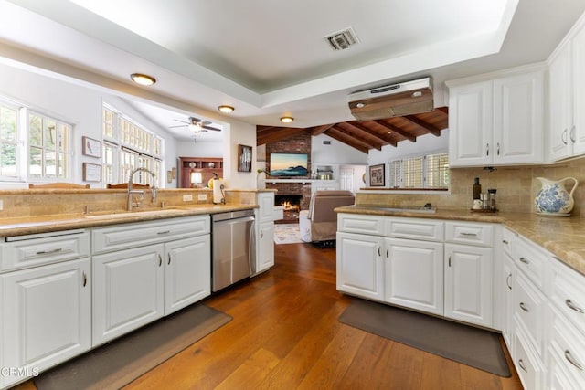 2210 Brambling Ln, Pasadena, CA 91107 - kitchen with stainless steel dishwasher, a brick fireplace, a peninsula, and white cabinetry