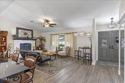 22150 Buena Vista St, Tehachapi, CA 93561 - living area with wood finished floors, a ceiling fan, a fireplace, lofted ceiling, and french doors