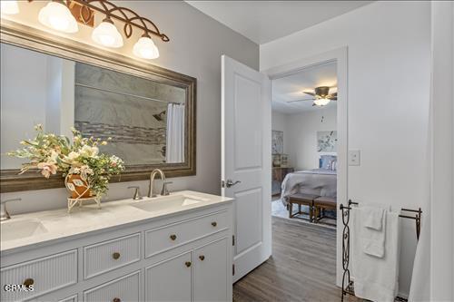 22150 Buena Vista St, Tehachapi, CA 93561 - ensuite bathroom featuring double vanity, wood finished floors, curtained shower, and a ceiling fan