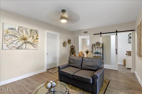 22150 Buena Vista St, Tehachapi, CA 93561 - living area with a barn door, wood finished floors, and ceiling fan