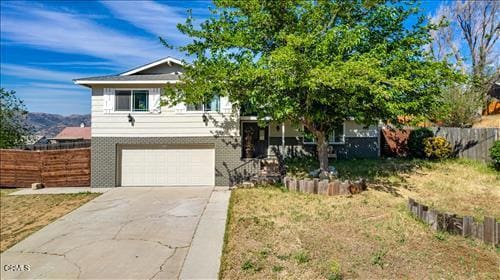 22150 Buena Vista St, Tehachapi, CA 93561 - view of front of house featuring an attached garage, driveway, and brick siding