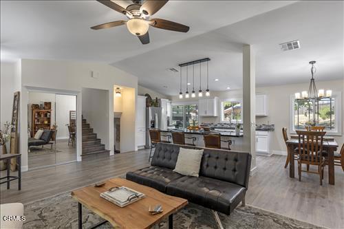22150 Buena Vista St, Tehachapi, CA 93561 - living area featuring light wood-style flooring, a ceiling fan, lofted ceiling, a chandelier, and stairs