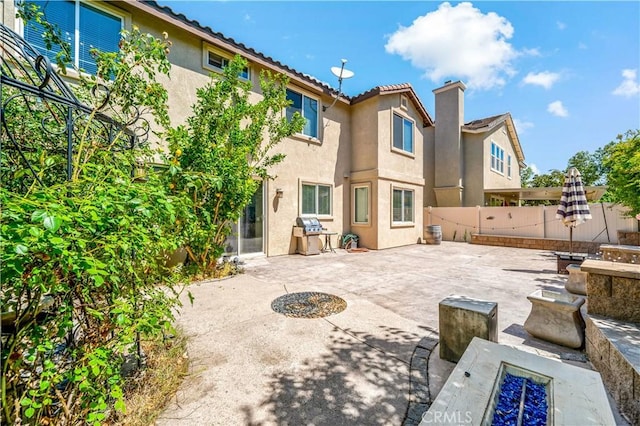 4127 Poplar Cir, Lake Elsinore, CA 92530 - rear view of house featuring stucco siding, a patio, a fenced backyard, a chimney, and a tiled roof