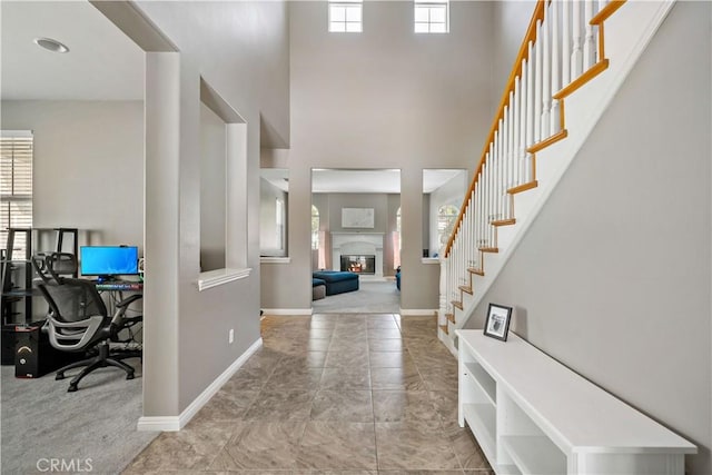 4127 Poplar Cir, Lake Elsinore, CA 92530 - foyer featuring plenty of natural light, a high ceiling, a glass covered fireplace, and stairs