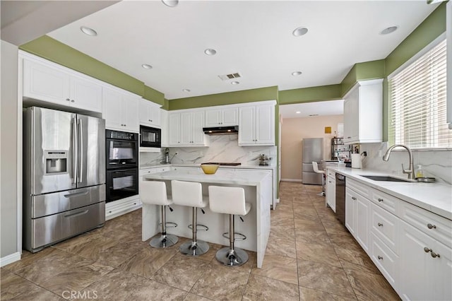 4127 Poplar Cir, Lake Elsinore, CA 92530 - kitchen featuring black appliances, under cabinet range hood, decorative backsplash, white cabinetry, and recessed lighting
