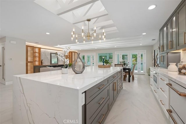 5437 Via Carrizo, Laguna Woods, CA 92637 - kitchen with french doors, gray cabinetry, a large island, recessed lighting, and light stone countertops