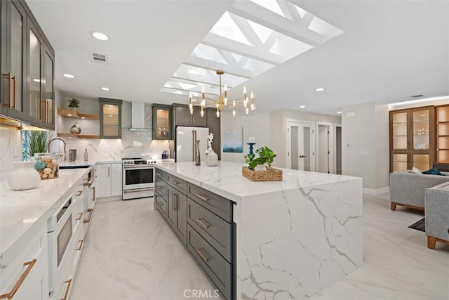 5437 Via Carrizo, Laguna Woods, CA 92637 - kitchen with wall chimney exhaust hood, fridge, stainless steel stove, tasteful backsplash, and glass insert cabinets
