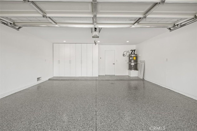 5437 Via Carrizo, Laguna Woods, CA 92637 - garage with strapped water heater, a garage door opener, and baseboards