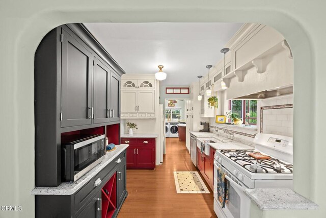 346 Stedman Pl, Monrovia, CA 91016 - kitchen featuring stainless steel appliances, independent washer and dryer, light wood-style flooring, backsplash, and arched walkways
