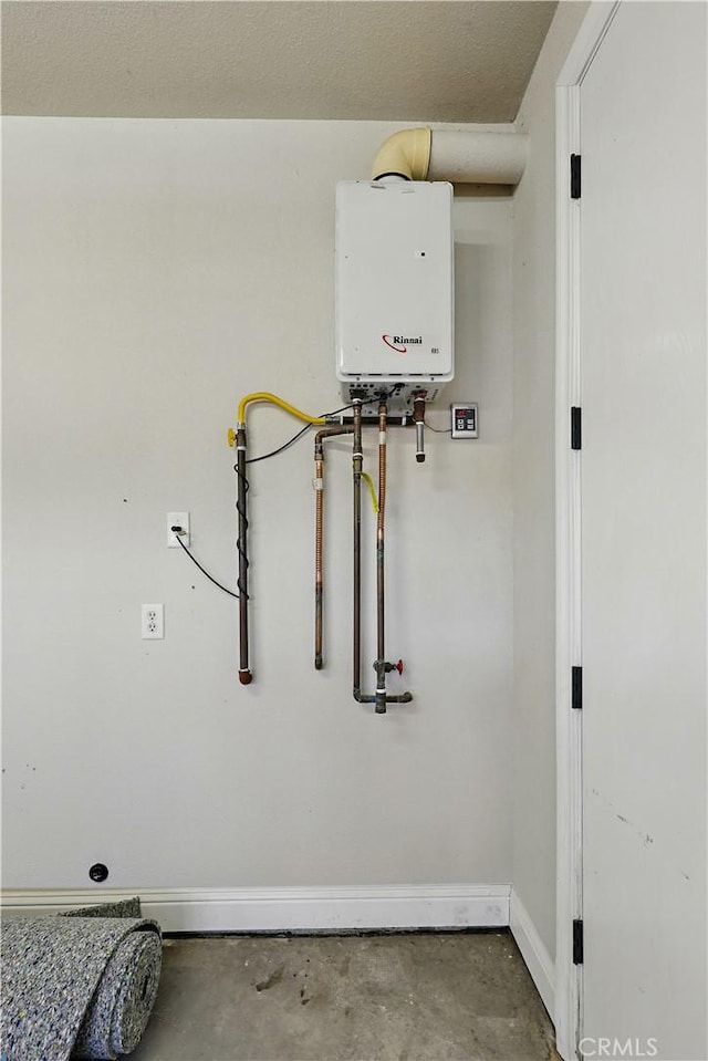 13045 Ridgewood Way, Chowchilla, CA 93610 - detailed view of tankless water heater, unfinished concrete flooring, and baseboards