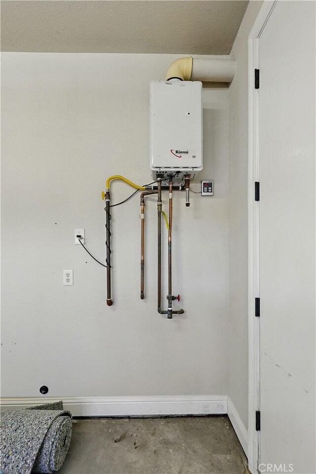 13045 Ridgewood Way, Chowchilla, CA 93610 - detailed view of tankless water heater, unfinished concrete floors, and baseboards