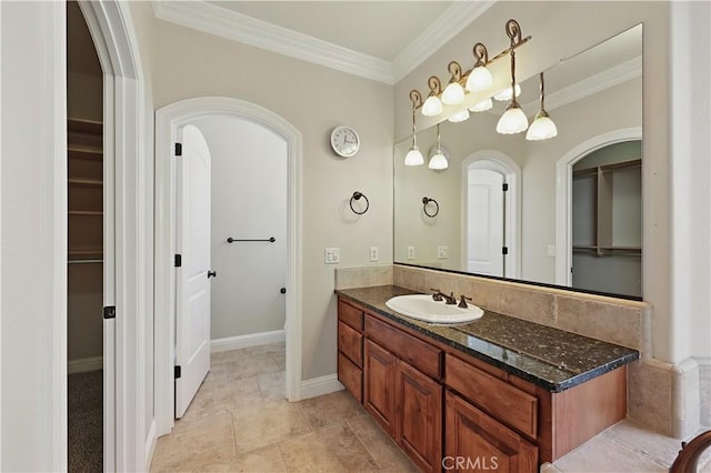13045 Ridgewood Way, Chowchilla, CA 93610 - bathroom featuring vanity, crown molding, a walk in closet, and baseboards
