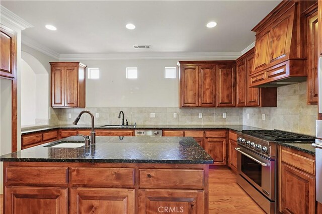 13045 Ridgewood Way, Chowchilla, CA 93610 - kitchen with stainless steel stove, a sink, dark stone counters, crown molding, and light wood-type flooring