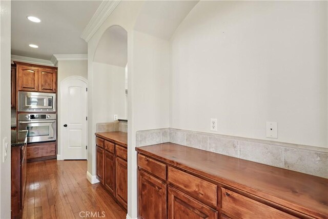 13045 Ridgewood Way, Chowchilla, CA 93610 - kitchen with stainless steel appliances, crown molding, dark wood-style floors, recessed lighting, and arched walkways