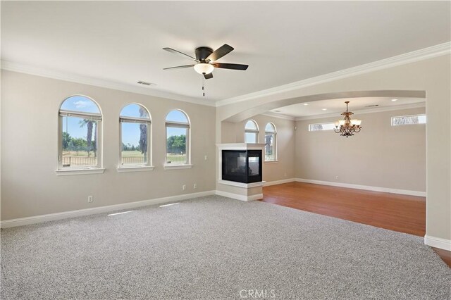 13045 Ridgewood Way, Chowchilla, CA 93610 - unfurnished living room featuring crown molding, a chandelier, carpet floors, a multi sided fireplace, and baseboards