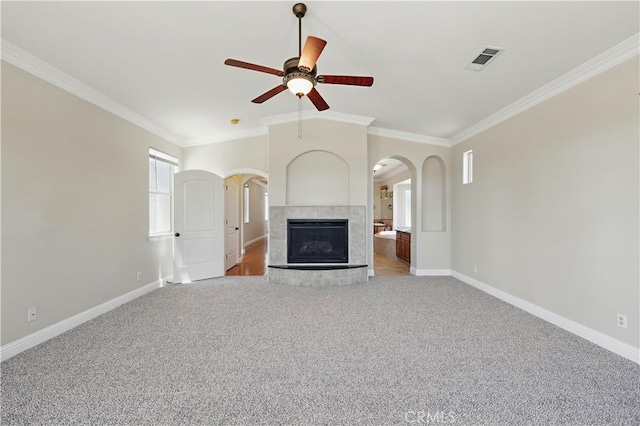 13045 Ridgewood Way, Chowchilla, CA 93610 - unfurnished living room featuring arched walkways, crown molding, a ceiling fan, light colored carpet, and baseboards