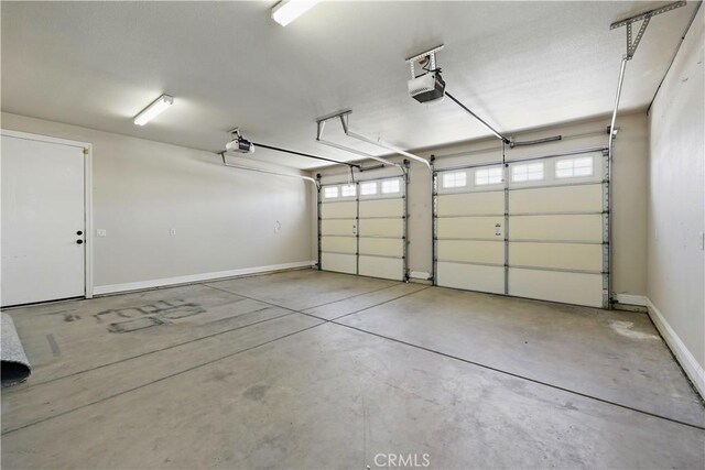 13045 Ridgewood Way, Chowchilla, CA 93610 - garage with a garage door opener and baseboards