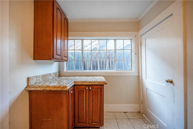 1914 S W View St, Los Angeles, CA 90016 - kitchen featuring light countertops, brown cabinetry, ornamental molding, baseboards, and light tile patterned floors