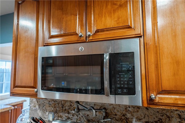 1914 S W View St, Los Angeles, CA 90016 - kitchen view of stainless steel microwave, brown cabinets, and light stone counters