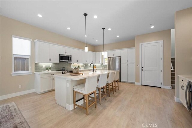 176 Tango Way, San Luis Obispo, CA 93401 - kitchen with stainless steel appliances, light countertops, white cabinets, a breakfast bar, and recessed lighting