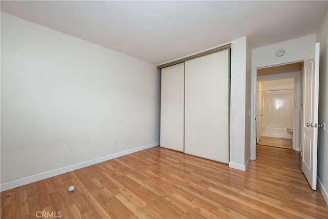 3505 Angelucci St Unit 2E, San Diego, CA 92111 - unfurnished bedroom featuring light wood-style floors, a closet, and baseboards