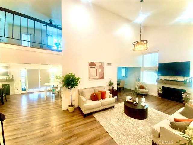 2416 Hialeah Cir, Norco, CA 92860 - living area featuring a towering ceiling, a fireplace, wood finished floors, and baseboards