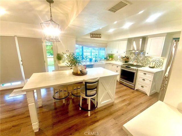 2416 Hialeah Cir, Norco, CA 92860 - kitchen featuring wall chimney exhaust hood, stainless steel range with gas stovetop, white cabinets, and a sink