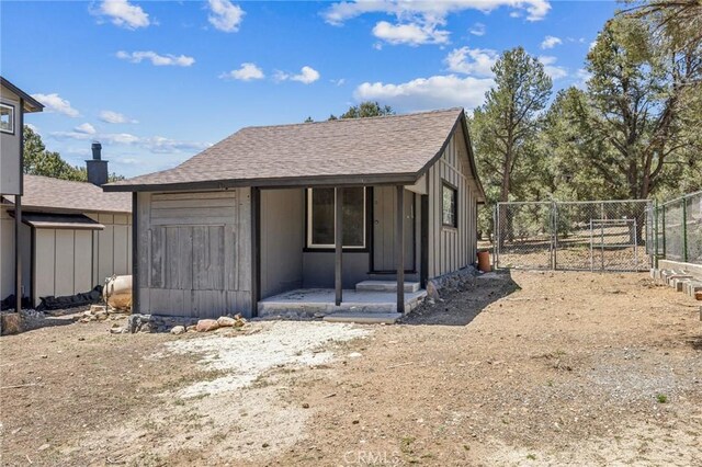 1850 Pond, Big Bear City, CA 92314 - view of front facade featuring a gate, board and batten siding, and roof with shingles