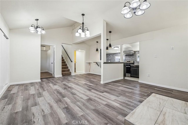 1850 Pond, Big Bear City, CA 92314 - unfurnished living room featuring a chandelier, lofted ceiling, wood finished floors, stairs, and baseboards