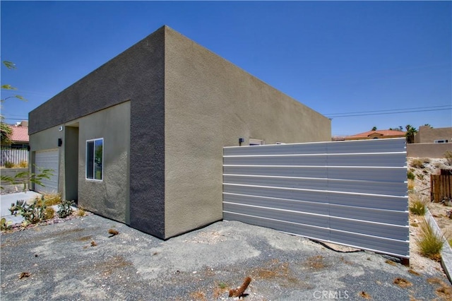 12612 Maui Way, Desert Hot Springs, CA 92240 - view of property exterior with stucco siding and a garage