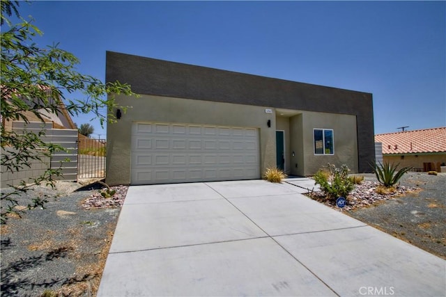 12612 Maui Way, Desert Hot Springs, CA 92240 - view of front of home with driveway, stucco siding, an attached garage, and a gate