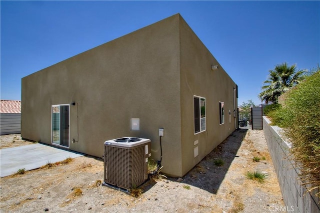 12612 Maui Way, Desert Hot Springs, CA 92240 - view of side of home featuring central air condition unit, stucco siding, and a patio area