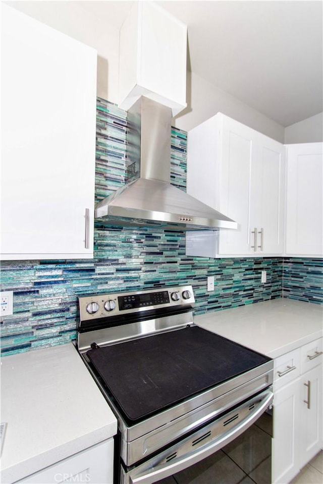 12612 Maui Way, Desert Hot Springs, CA 92240 - kitchen featuring electric stove, wall chimney exhaust hood, light countertops, white cabinetry, and decorative backsplash